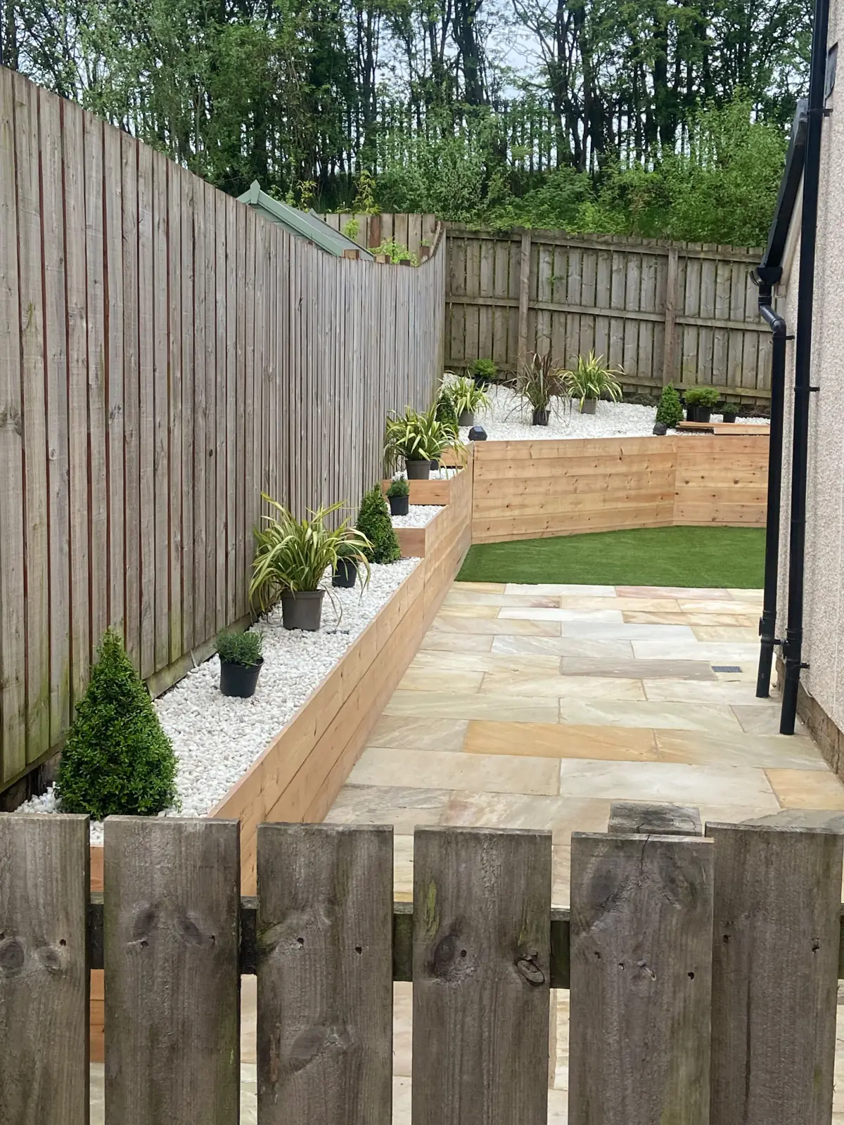 Raised sleeper beds, sandstone path and artificial grass