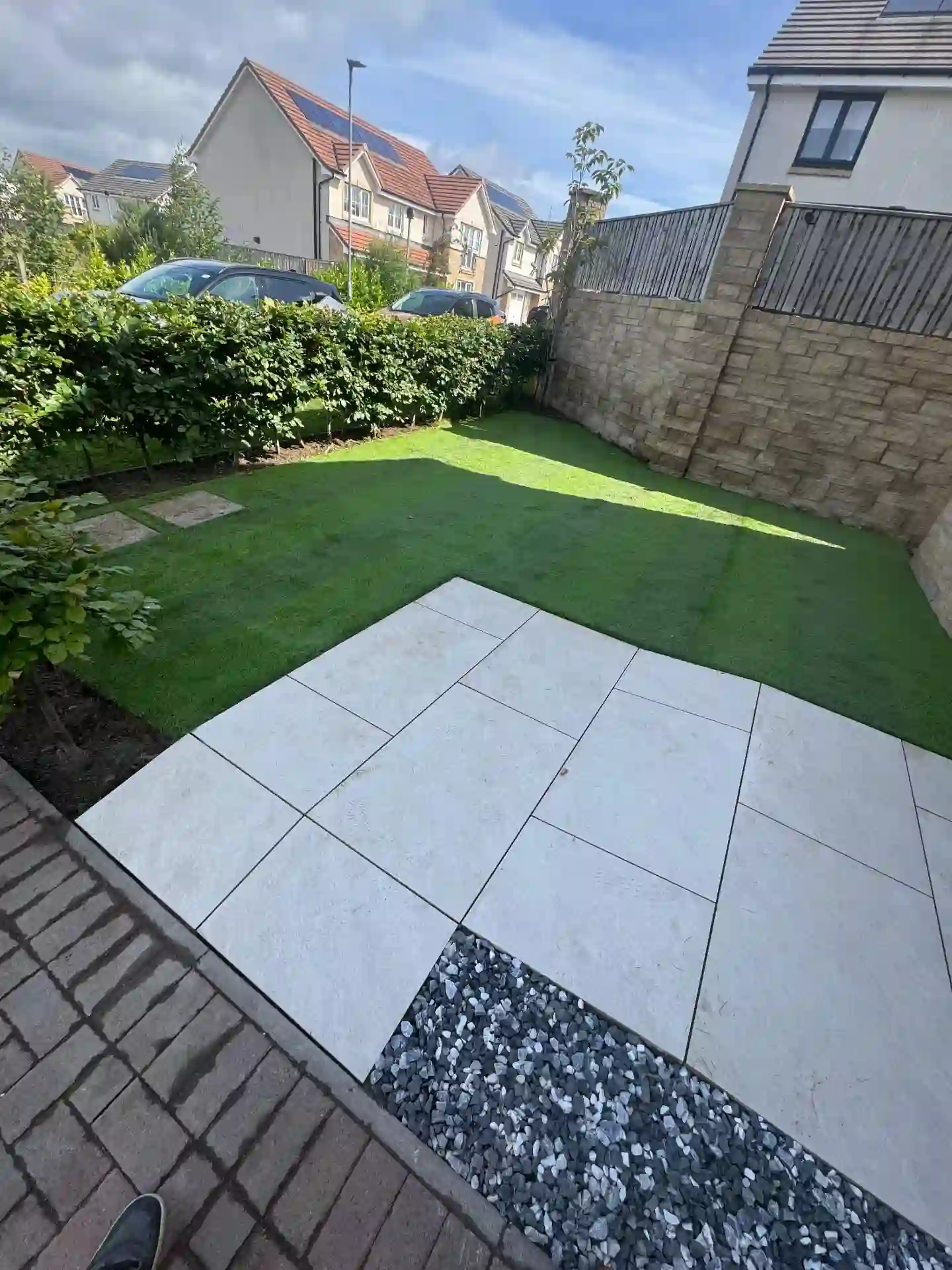Porcelain patio, new lawn and slate gravel border with stone wall