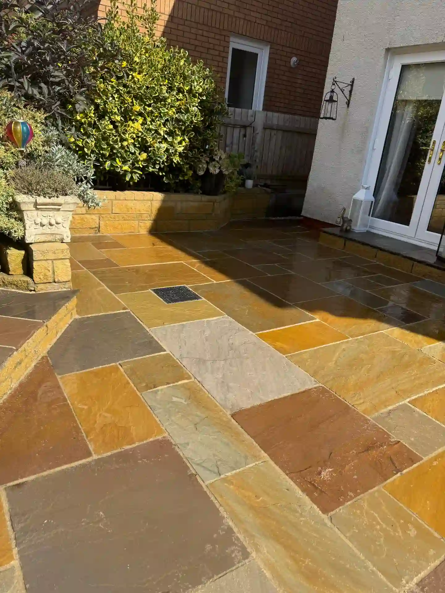 Indian sandstone patio with golden brick raised beds