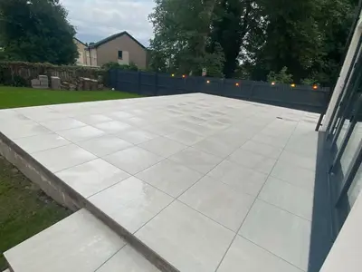 Raised paved patio with steps and fence lighting