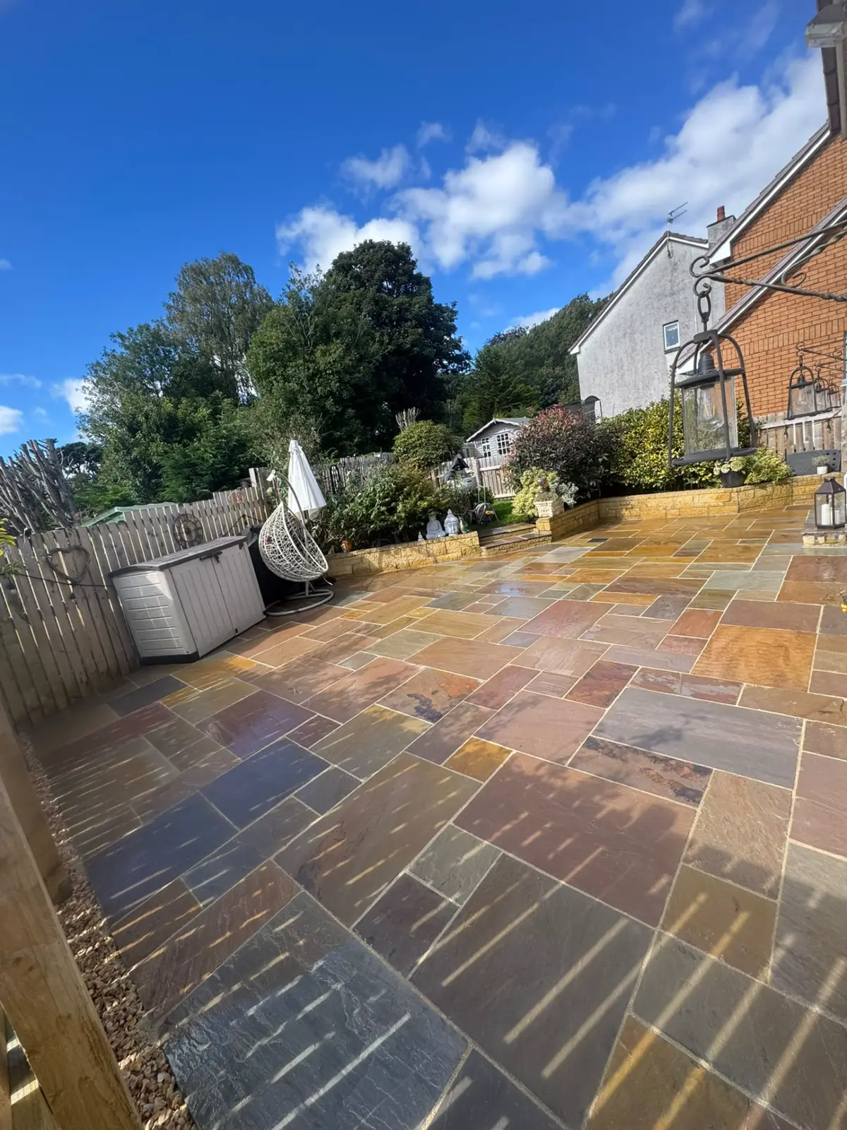 Same garden after: new sandstone patio with stone-walled raised beds