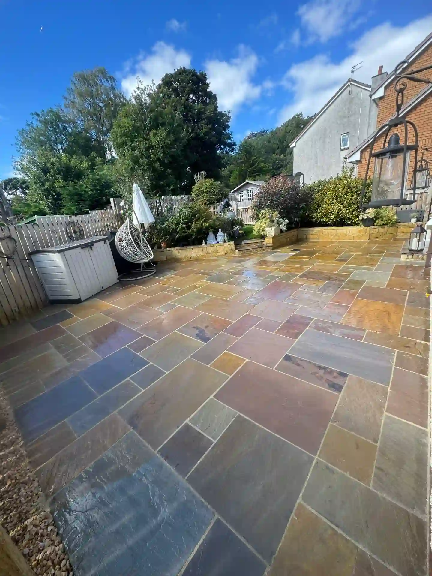 Large Indian sandstone patio with seating and garden wall