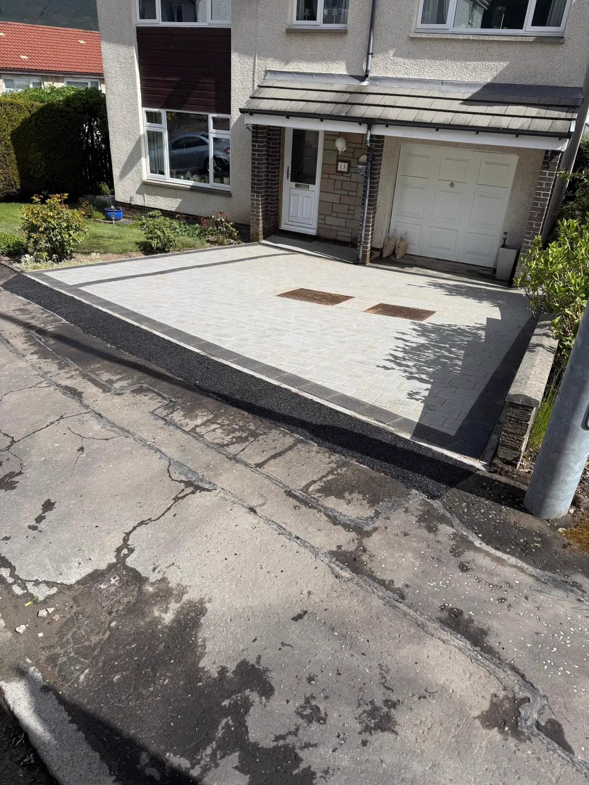 Silver-grey block paved driveway with charcoal edging and new tarmac apron
