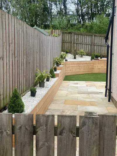 Raised sleeper beds, sandstone path and artificial grass